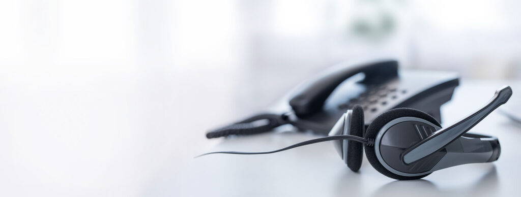 Foto schwarzes Telefon mit Headset auf Schreibtisch im hellen Zimmer